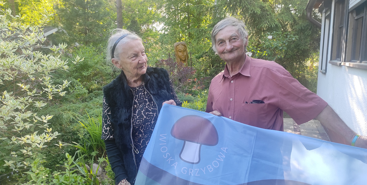 Sołtys Jan Maniowski i pisarka Alina Wajda prezentują flagę Wioski Grzybowej, jaką stał się Krzywogoniec.