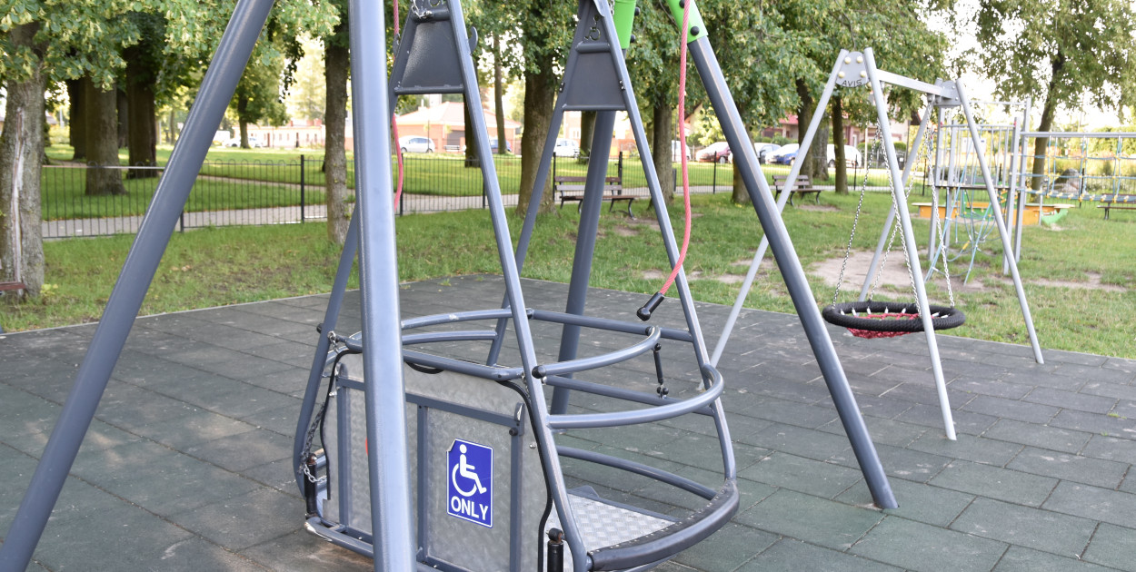 Huśtawka dedykowana osobom poruszającym się na wózkach inwalidzkich. Takie urządzenie znajduje się na placu zabaw w Chojnicach, zlokalizowanym w sąsiedztwie Chojnickiego Centrum Kultury.