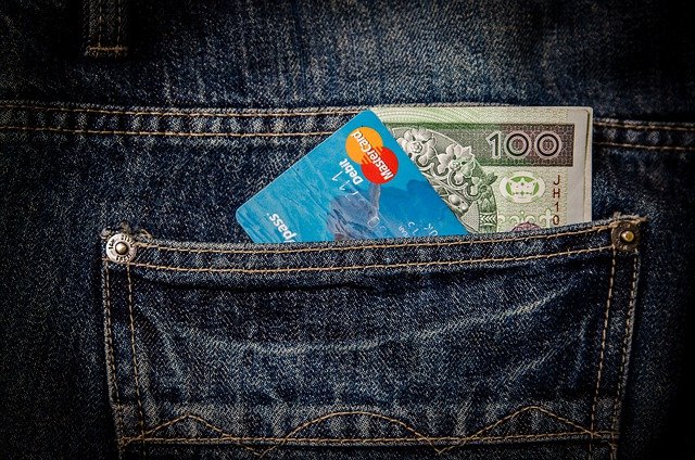 banknot 100-złotowy z małej pożyczki i karta płatnicza w spodniach
